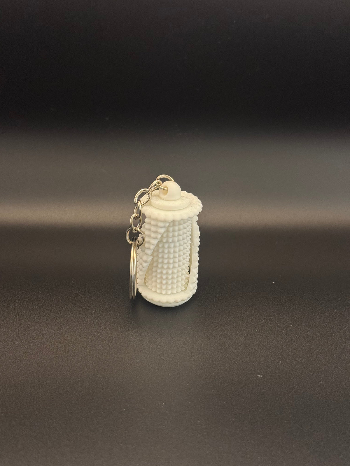 Grenade fidget spinner keyring on dark surface